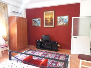 a living room with a red wall at Vila Gjoka in Himare