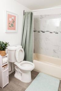 a white bathroom with a toilet and a shower at A stunning 2bedroom 2bath private home near Sofi Stadium, Kia Forum, and Intuit Dome in Los Angeles