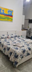 a bedroom with a bed with a blue and white comforter at le ginestre in centro in Salerno