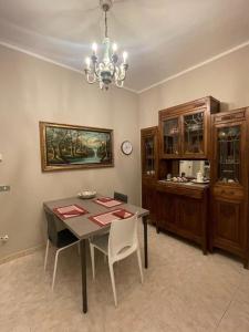 una sala da pranzo con tavolo e lampadario pendente di Appartamento Borgosesia Cuore Matto a Borgosesia