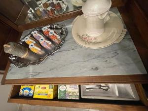 a counter top with a table with a tea pot and a plate at Appartamento Borgosesia Cuore Matto in Borgosesia