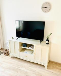 a white entertainment center with a flat screen tv on top at Inselliebe Norderney in Norderney