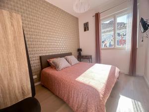 a bedroom with a bed and a window at Face Cité - Chambres D'Hôtes - Parking & Garage Gratuit - Wi-Fi Gratuit in Carcassonne