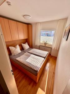 ノルダーナイにあるInselliebe Norderneyの小さなベッドルーム(窓付きのベッド付)
