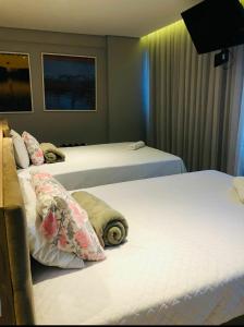 una camera d'albergo con due letti con cuscini di flatpaivahome bugan paiva a Recife