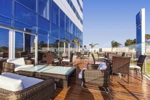 un patio con sedie e tavoli in vimini in un edificio di flatpaivahome bugan paiva a Recife