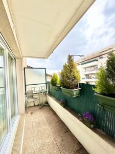 d'un balcon avec une table et des plantes sur une clôture. dans l'établissement Appartement VILLA NOVA proche de Paris-Stade de France, à Drancy