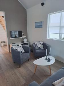 a living room with two chairs and a table at Nýlegur sumarbústaður/friðsæld in Mosfellsbær