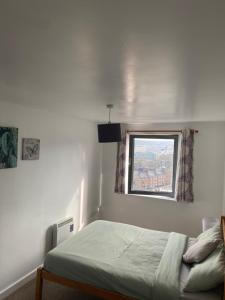 a bedroom with a bed and a window at EEJs Beautiful 2 bed Apartment - Sheffield centre in Sheffield +4 photos