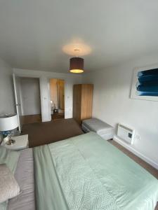 a bedroom with a large bed and a couch at EEJs Beautiful 2 bed Apartment - Sheffield centre in Sheffield
