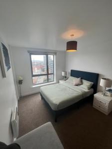 a bedroom with a bed and a window at EEJs Beautiful 2 bed Apartment - Sheffield centre in Sheffield
