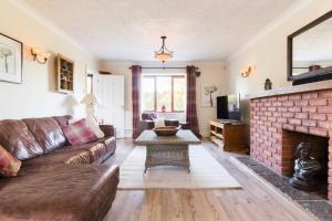 un soggiorno con divano e camino di Stratford House - Perfect for a get together a Upton Snodsbury