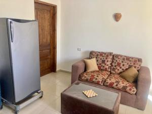 a living room with a couch and a refrigerator at Charming Garden near Beach+bike in Dahab