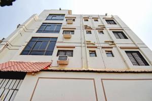 a tall white building with windows and a roof at Hotel Elite Inn Ultadanga Inn Kolkata in Kolkata