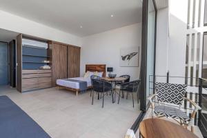 Habitación con cama, mesa y sillas. en Nuevo y lujoso estudio céntrico, en Playa del Carmen