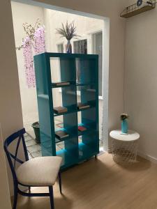 a blue book shelf with a chair in a room at Barão 35 Guest House in Braga