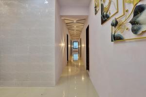a hallway of a building with white walls and white floors at Vr Hotel in Surat