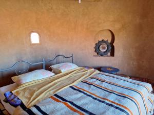 M'hamid Desert Camp Tours في امحاميد: غرفة نوم بسرير وساعة على الحائط