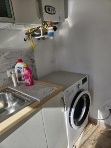 una piccola cucina con lavatrice e lavandino di Casa Mary a Camaiore