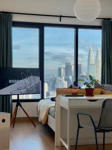 a bedroom with a desk and a view of a city at Rooms with KLCC and KL Tower view by Yee in Kuala Lumpur
