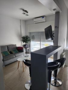 a kitchen and living room with a counter and chairs at Departamento 1 dormitorio amueblado in Bahía Blanca