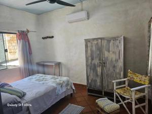 ein Schlafzimmer mit einem Bett, einem Stuhl und einem Ventilator in der Unterkunft Espacios amplios con terraza y piscina spa in San Lorenzo