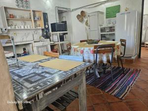 a kitchen with a table and a refrigerator at Espacios amplios con terraza y piscina spa in San Lorenzo