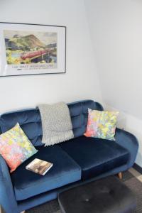 a blue couch with colorful pillows in a living room at Tigh Na Beithe in North Ballachulish