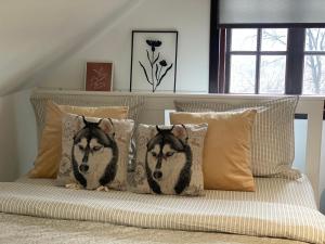 dos almohadas de lobo en una cama en un dormitorio en Chalet Husky en Şotrile