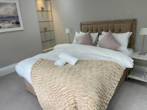 a bedroom with a large bed with two towels on it at Falcon suits in London