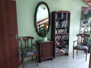 a room with two chairs and a dresser with a mirror at Hotel Restaurant Niemerich in Pulversheim