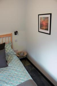 a bedroom with a bed and a table with a picture on the wall at Tigh Na Beithe in North Ballachulish