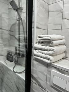 un mucchio di asciugamani seduti su una mensola in bagno di Casa Ștefan a Eforie Sud Altre 37 foto