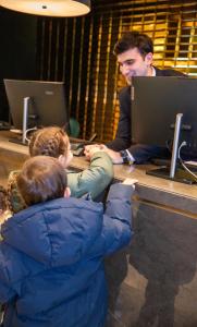 un homme et deux enfants assis à une table avec des ordinateurs portables dans l'établissement Hyatt Regency Baku, à Baku