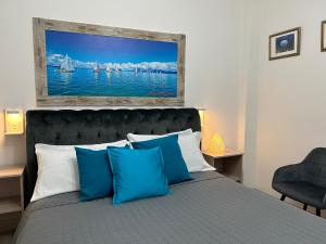 una camera da letto con un letto con cuscini blu e un dipinto di Dolce Dormire a Castiglione del Lago
