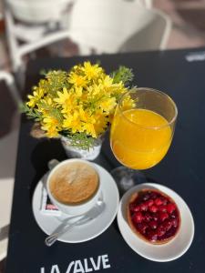 a tray with a cup of coffee and a bowl of fruit at Hotel Villa De Ermua in Ermua