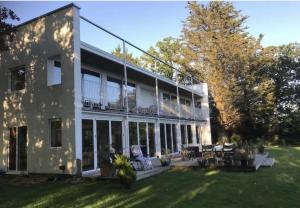 a large white house with a yard at A House in the Woods in Chiddingly