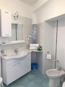 La salle de bains blanche est pourvue d'un lavabo et de toilettes. dans l'établissement Hotel Villa Antonio, à Ischia