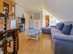 a living room with a blue couch and a table at Wassergans in Greetsiel