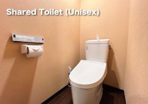 a bathroom with a white toilet in a room at Hostel Murasaki Ryokan Miyagawa in Takayama