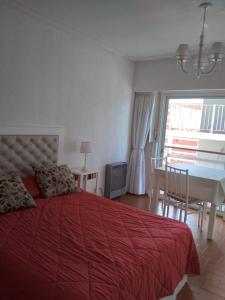 a bedroom with a bed and a table and a dining room at Departamento en la PLAYA Y CENTRO de Miramar para 3 personas in Miramar