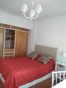 a bedroom with a red bed with two pillows at Departamento en la PLAYA Y CENTRO de Miramar para 3 personas in Miramar +22 photos