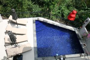 an overhead view of a swimming pool with two chairs at Rumah Riang in Mayong