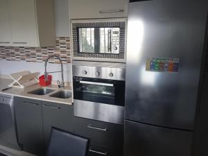 a kitchen with a stainless steel refrigerator and a sink at Sofia home in San Antonio de Benagéber