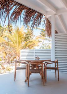 einem Tisch und einer Bank vor einem Fenster in der Unterkunft Sorobon Luxury Beach Resort in Kralendijk