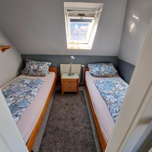 two beds in a small room with a window at Apartment Boje in Büsum