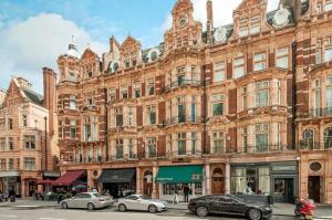 a large brick building with cars parked in front of it at Lux, Large Central Mayfair Location Flat in London