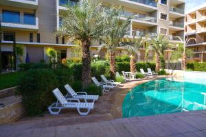 una piscina con tumbonas y un hotel en Appartement La Perle en Marrakech