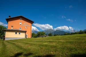a building in a field with a grassy field at Hotel Ristorante Sagittario in Feltre