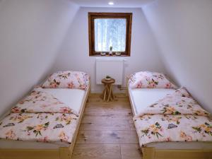 2 camas en una habitación con ventana en Chata pod lesíkom, en Lazisko